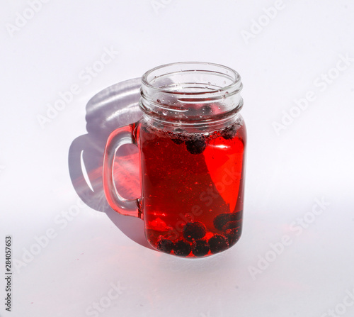summer berry lemonade in glass jar-mug with lid and  straw on  white background.