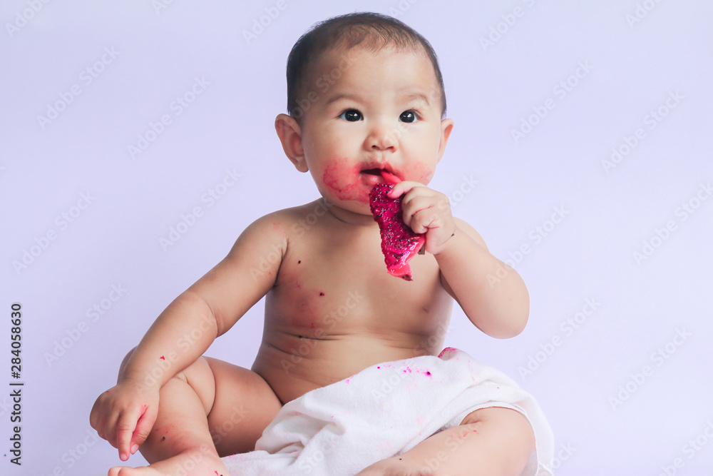 asian cute baby girl eating red dragon fruit. newborn baby on white background asian cute baby girl eating red dragon fruit. newborn baby on white background