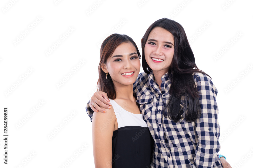 Happy two asian woman embrace and smiling looking at camera Happy two asian woman embrace and smiling looking at camera