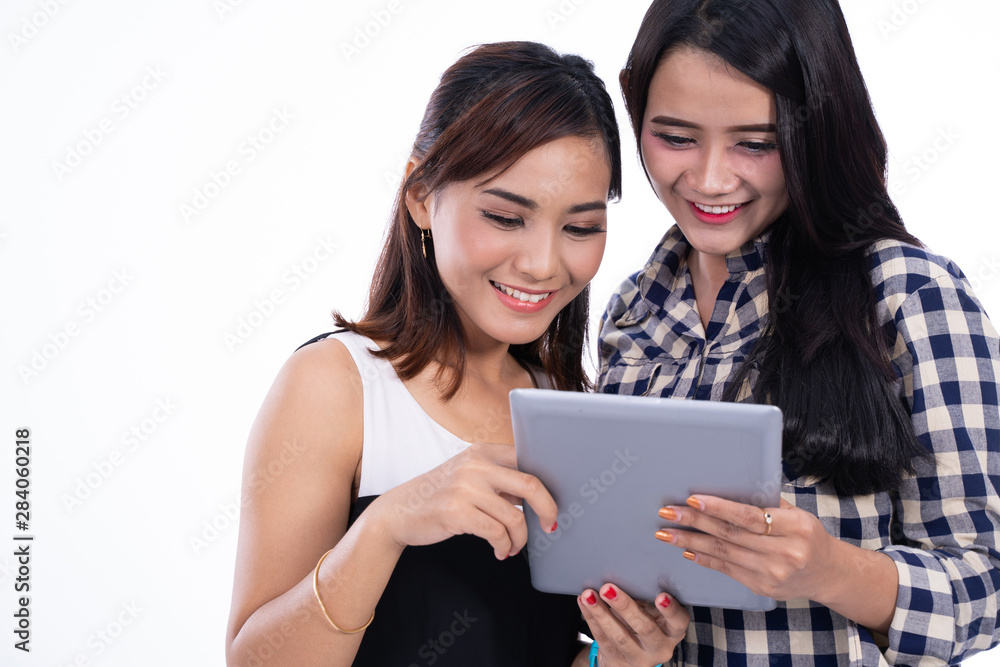 young girl friend using tablet in isolated background young girl friend using tablet in isolated background