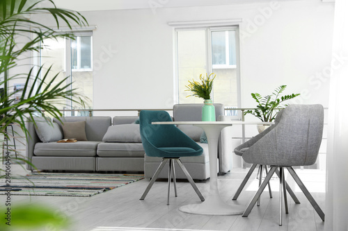 Fototapeta Naklejka Na Ścianę i Meble -  Modern living room interior with round table and stylish chairs