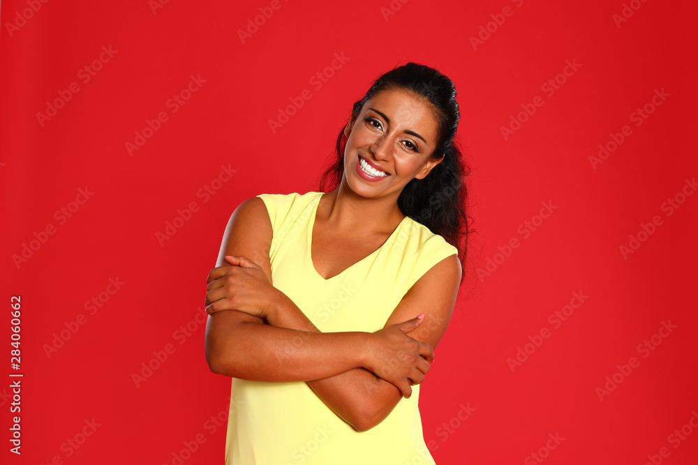 Beautiful Hispanic woman posing on red background Beautiful Hispanic woman posing on red background