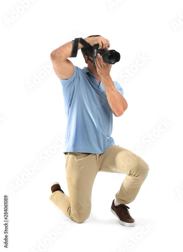 Young professional photographer taking picture on white background © New Africa