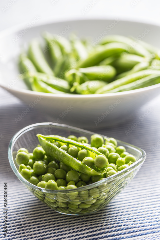 Fresh green pea seeds in bowl on kitchen table Fresh green pea seeds in bowl on kitchen table