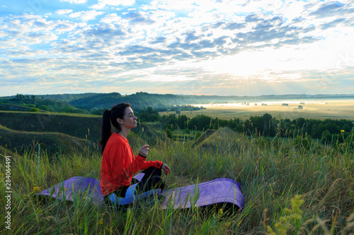 Girl in the nature doing yoga exercise for fitness.
