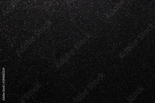 Black glitters abstract shiny background. Design paper texture for decoration and design of Christmas, New Year or other holiday pictures. Beautiful packaging material.