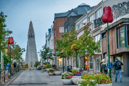 REYKJAVIK, ICELAND - AUGUST 11, 2019: City street with Cathedral on the background. The city hosts most of the island population