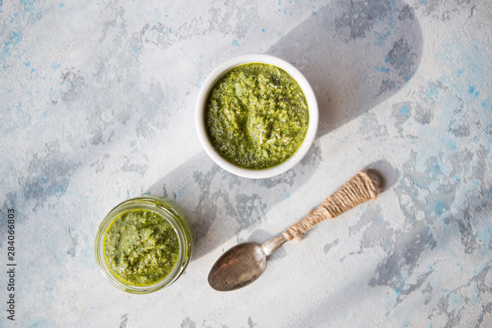 Vegetarian basil, garlic and walnut pesto. Close up of jar of homemade basil pesto with garlic. Vegetarian basil, garlic and walnut pesto. Close up of jar of homemade basil pesto with garlic.