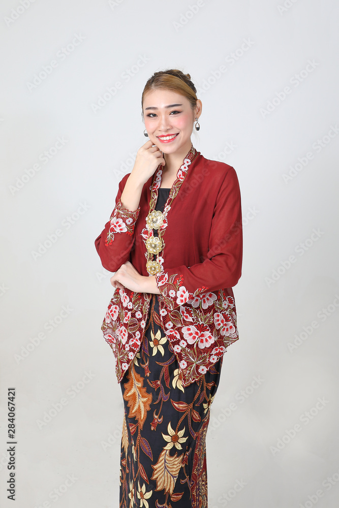 Asian woman traditional red maroon kebaya sharong on white background happy smile hand on cheek Asian woman traditional red maroon kebaya sharong on white background happy smile hand on cheek