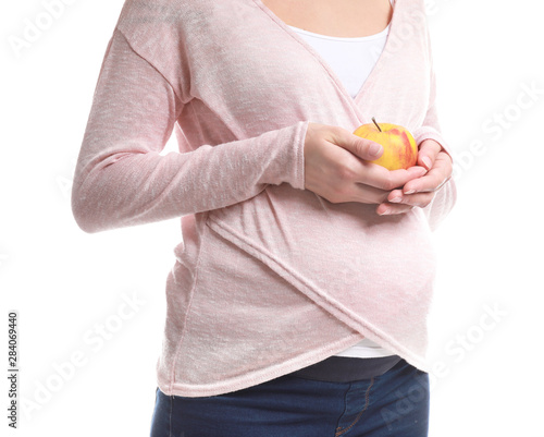 Beautiful pregnant woman with apple on white background