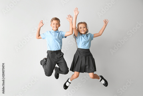 Quadro su tela Jumping little pupils on light background