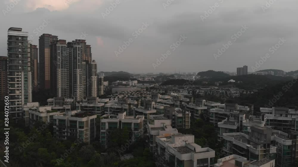 Residential complex in Guangzhou. Small residential buildings among green trees. On the side are multi-storey buildings. Residential complex in Guangzhou. Small residential buildings among green trees. On the side are multi-storey buildings.