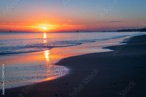 Sunrise over sandy beach shore