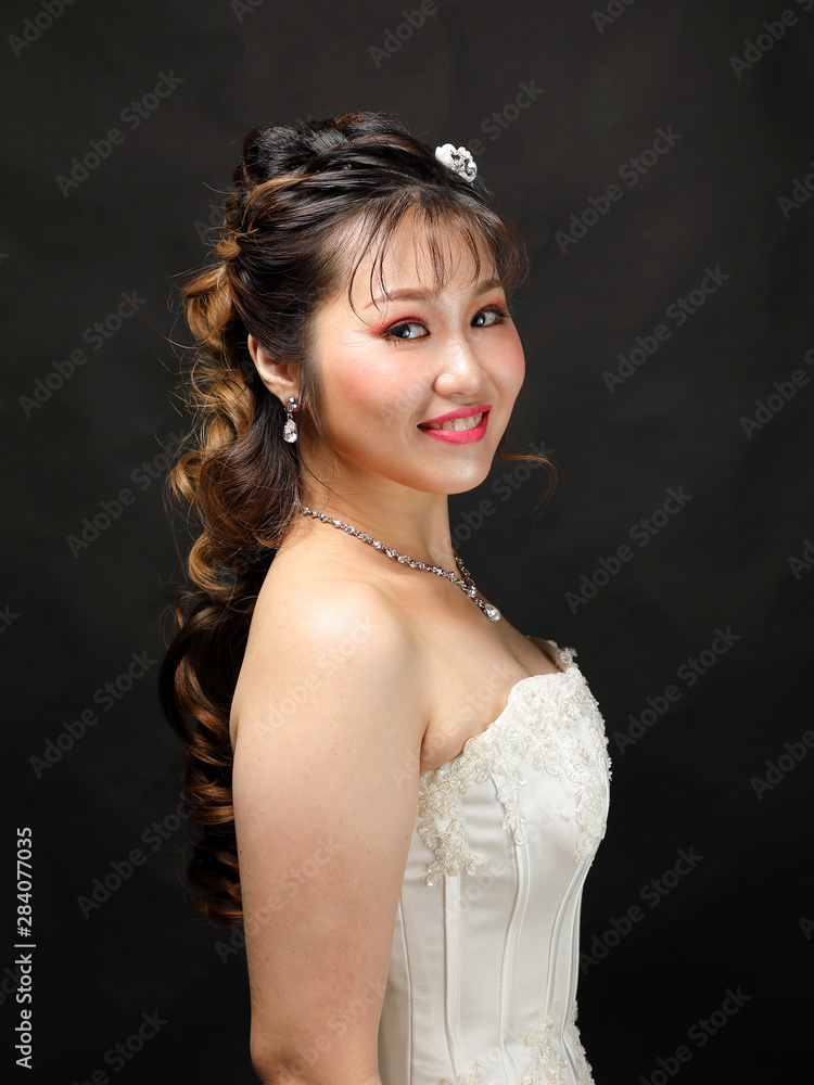 Young Asian woman in white dress hair crown on black background
