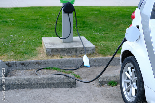 EV Car or Electric car at charging station with the power cable supply plugged in Eco-friendly alternative energy concept Vancouver