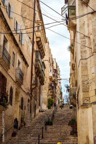 street with traditional balconies and old buildings in historical city Valletta Malta
