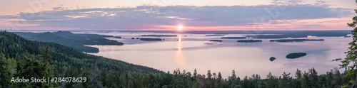 Very wide panorama view of sunrise behind lake Pielinen at summer in Koli National Park, Finland photo