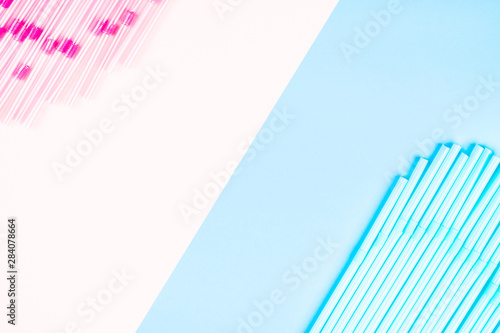 Blue and pink cocktail straws on a color background.