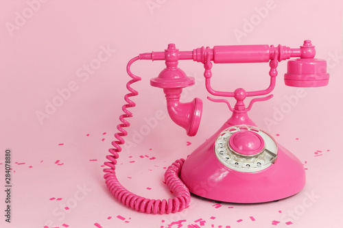 Pink vintage telephone on a pink background. Place for text. Minimalism. Concept. Texture Background