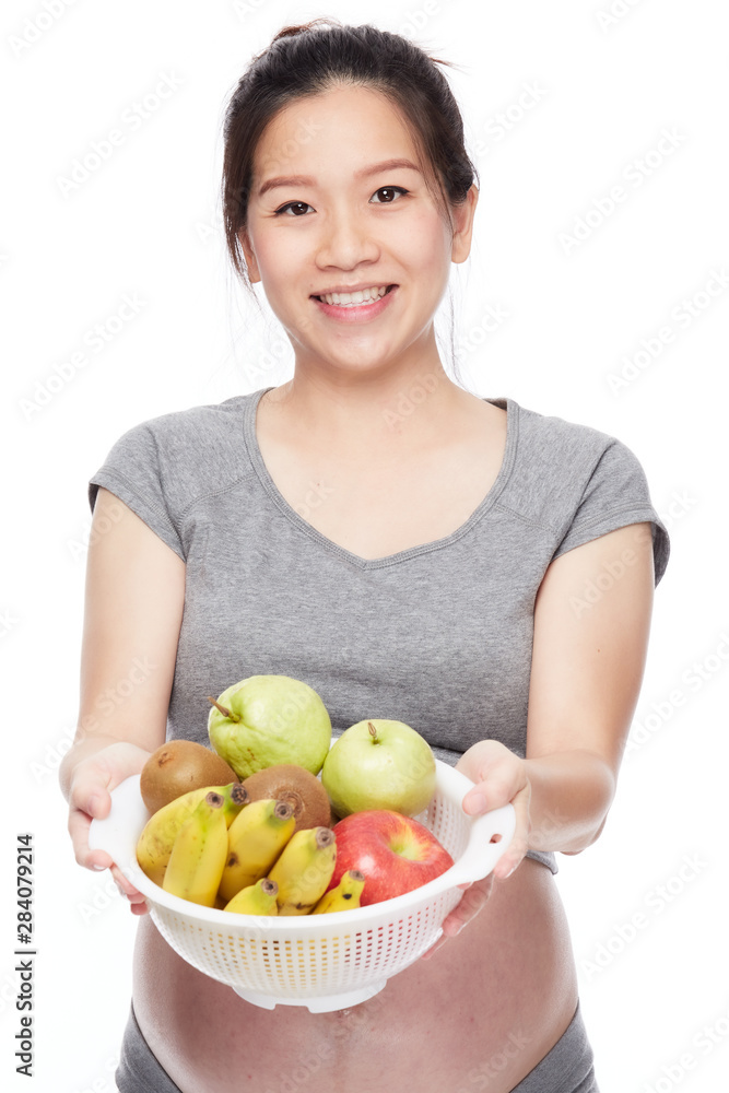 A portrait of a Happy pregnant woman with a bowl of fruits A portrait of a Happy pregnant woman with a bowl of fruits