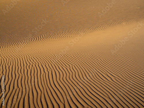 Fototapeta Naklejka Na Ścianę i Meble -  Sand dunes in Morocco, desert landscape, sand texture, tourist camp for night stay, panorama view of sunset over Sahara