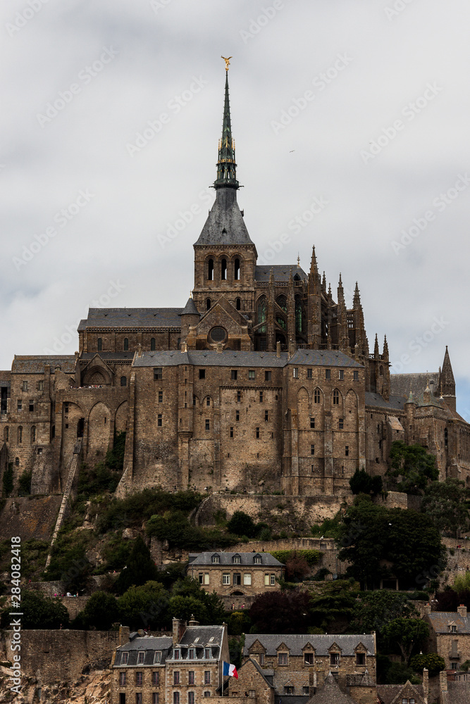 Close view of famous historic Le Mont Saint-Michel castle on a cloudy day in summer, Normandy, Northern France