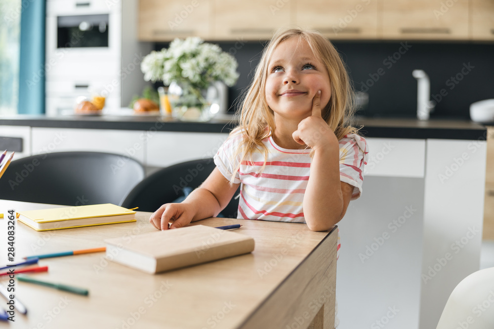 Curious kid at the table looking up stock photo Curious kid at the table looking up stock photo
