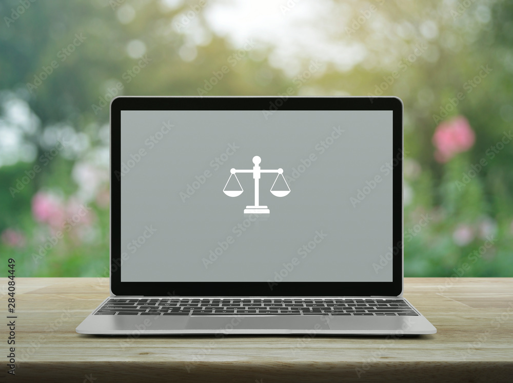 Law flat icon with modern laptop computer on wooden table over blur pink flower and tree in garden, Business legal service online concept Law flat icon with modern laptop computer on wooden table over blur pink flower and tree in garden, Business legal service online concept