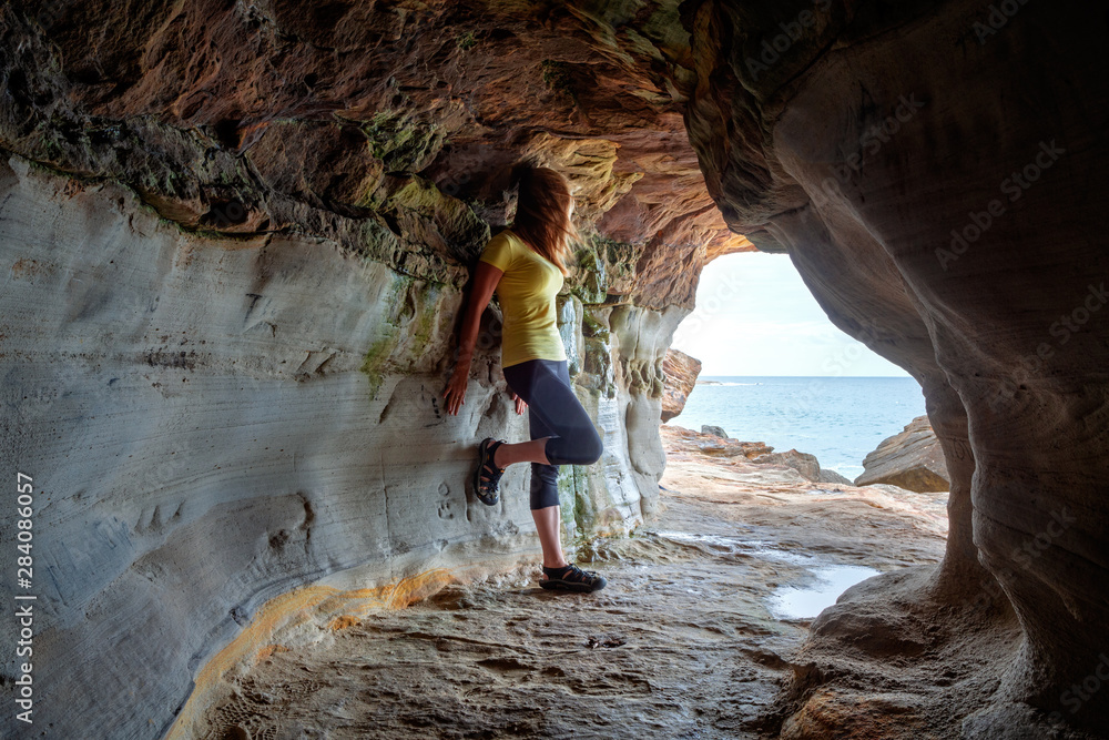 Woman standing in sandstone cave and tunnel