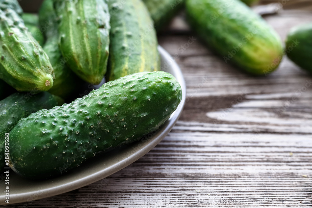 Fresh farm cucumbers in rustic plates on wooden background, copy space. Fresh farm cucumbers in rustic plates on wooden background, copy space.