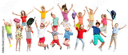 Group of elementary school kids or pupils jumping in colorful casual clothes jumping isolated on white studio background. Creative collage. Back to school  education  childhood concept.