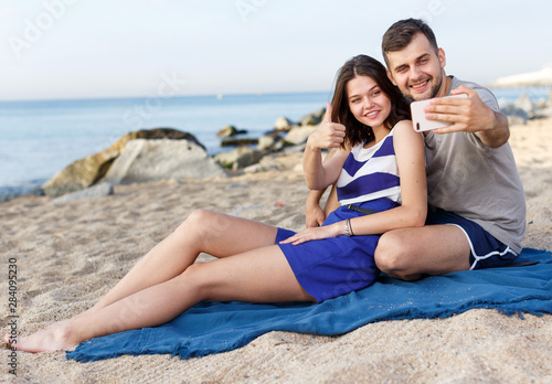 Happy loving couple resting and taking selfie