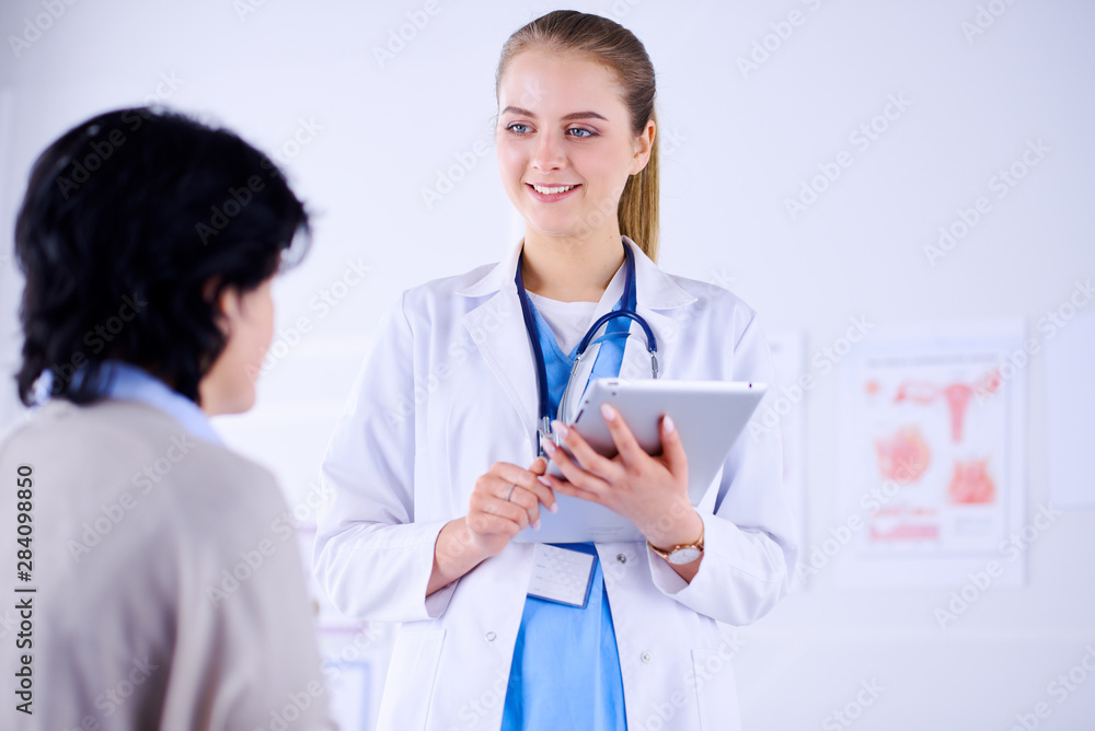 Doctor talking to a patient in a hospital and holding a tablet. Doctor talking to a patient in a hospital and holding a tablet.