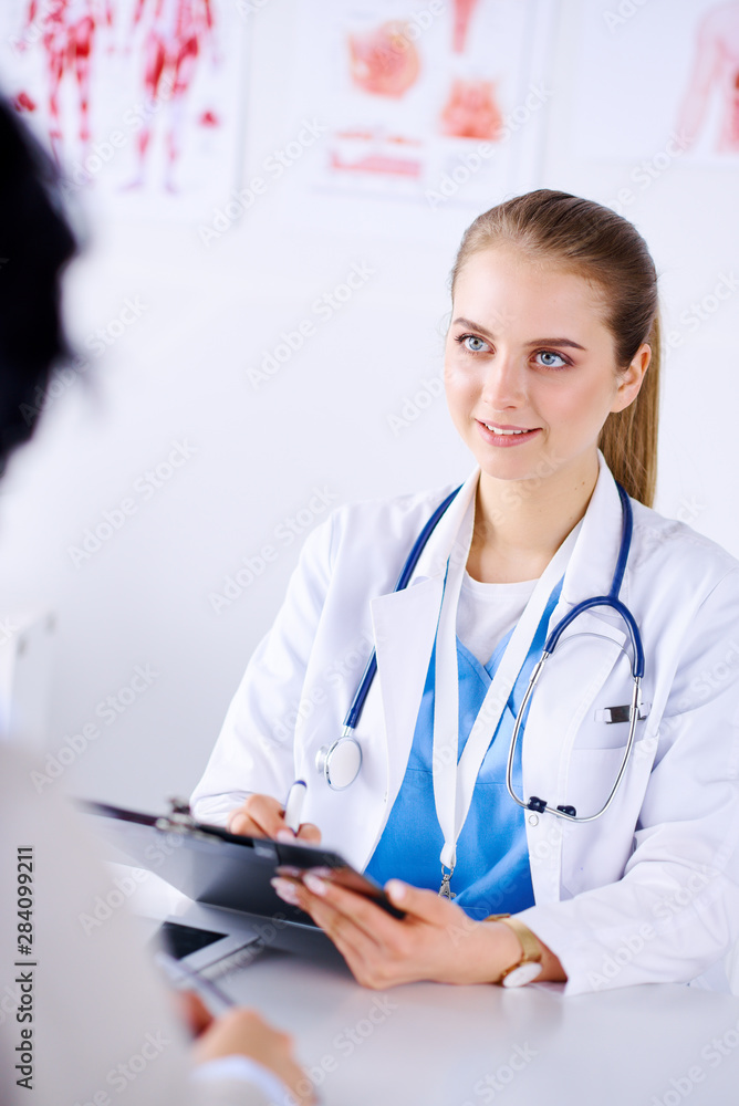 Female doctor consulting patient while filling up an application form at the desk in hospital. Just hands close-up. Medicine and health care concept Female doctor consulting patient while filling up an application form at the desk in hospital. Just hands close-up. Medicine and health care concept