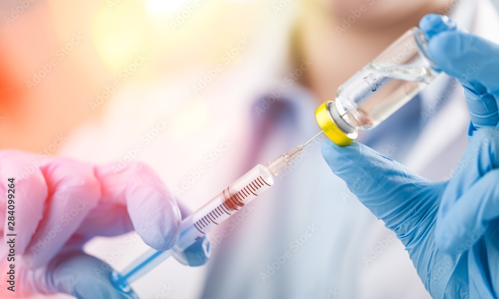 Hand holding syringe and vaccine. Hand holding syringe and vaccine.