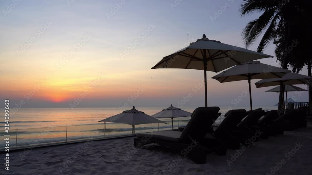 Sunset set scene over beach with lounge chairs and umbrellas Sunset set scene over beach with lounge chairs and umbrellas