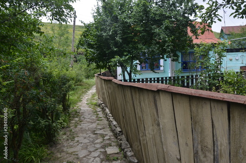 old wooden fence and blue house in village