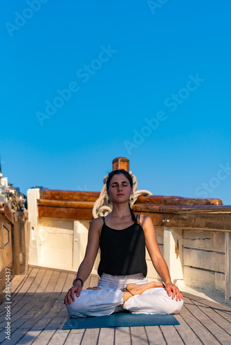 Woman practicing Yoga on a sailing yacht © Netfalls
