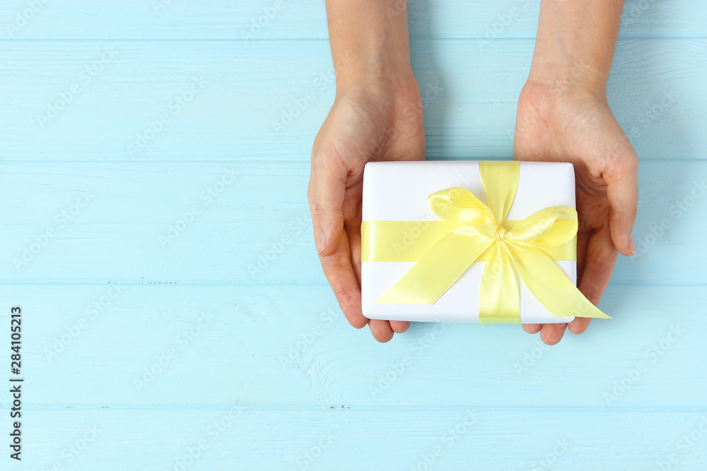 gift in female hands on a colored background top view. gift in female hands on a colored background top view.