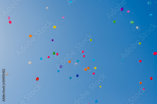 Balloons flying away into the blue sky