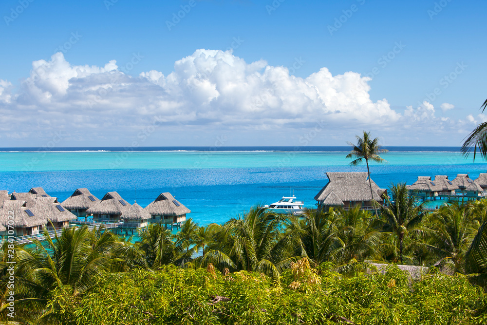 French Polynesia. Over water bungalows and palm trees..