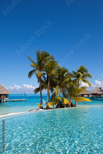 Fototapeta Naklejka Na Ścianę i Meble -  View of the sandy beach with palm trees and pool, Bora Bora, French Polynesia