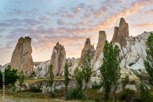 A unique rocky area at dawn with pink tender clouds. Cappadocia Turkey.