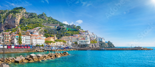 Fototapeta Naklejka Na Ścianę i Meble -  Panorama of Amalfi on hills leading down to coast, comfortable beaches and azure sea on Amalfi Coast in Campania, Italy