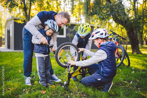 Fotografie Father's day A big friendly family father and three sons joint active rest outside