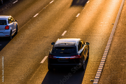 long shadows of car traffic on uk motorway at sunset in england