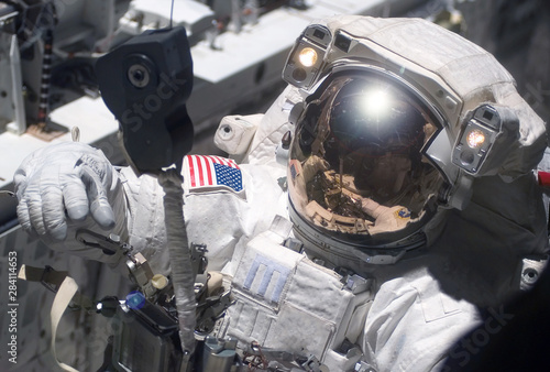 Fototapeta Naklejka Na Ścianę i Meble -  The astronaut in a space suit, in an outer space, is engaged in repair of the space station.  Elements of this image were furnished by NASA