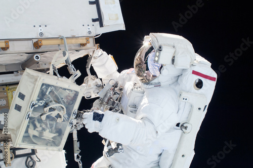 Fototapeta Naklejka Na Ścianę i Meble -  The astronaut in a space suit, in an outer space, is engaged in repair of the space station.  Elements of this image were furnished by NASA
