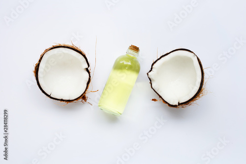 Coconut oil with coconuts on white