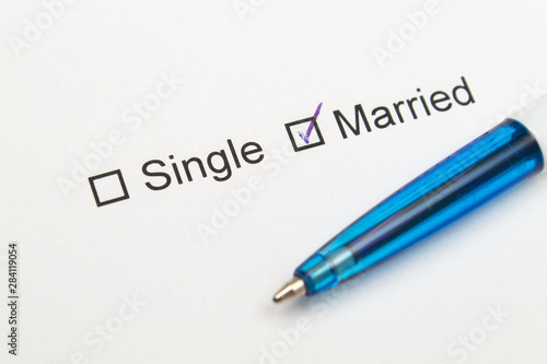 Single or married - checkmark on white paper with pen.